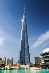 The Burj Khalifa building in Dubai against a blue sky.